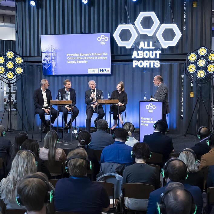 Podiumsdiskussion auf der Messebühne „All About Ports“ vor Fachpublikum während einer Branchenveranstaltung.